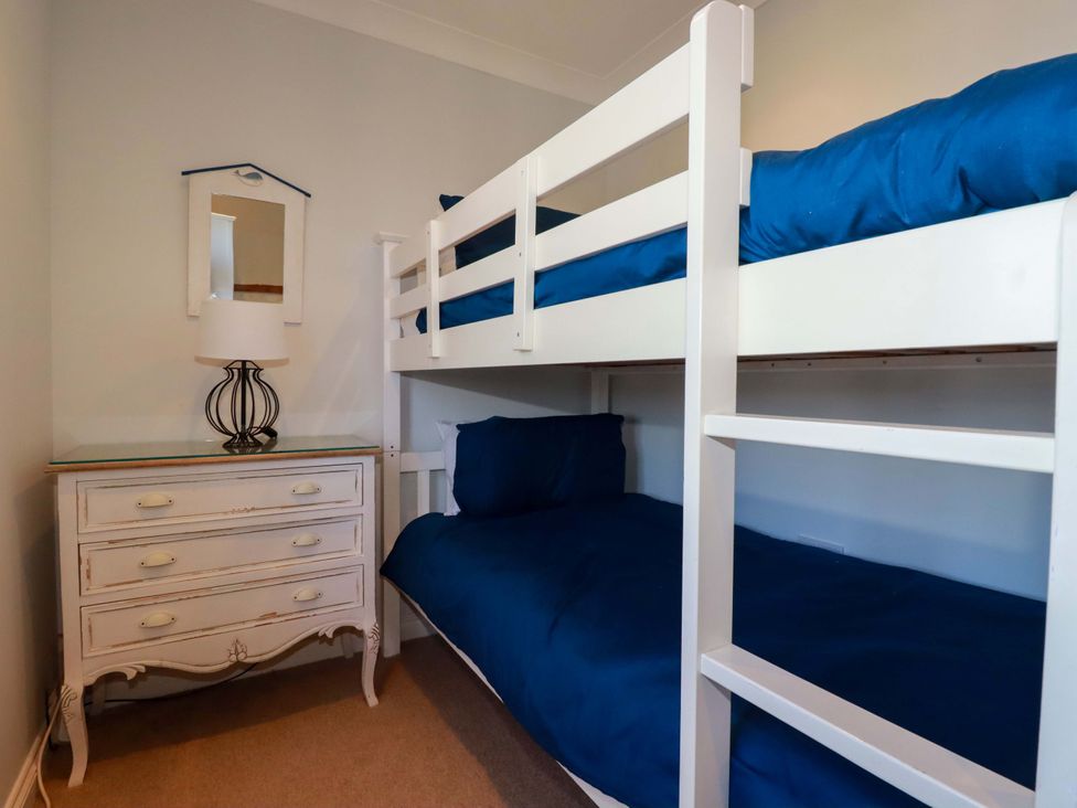 A bedroom with a bunk bed and a lamp at Trewollock in Mevagissey