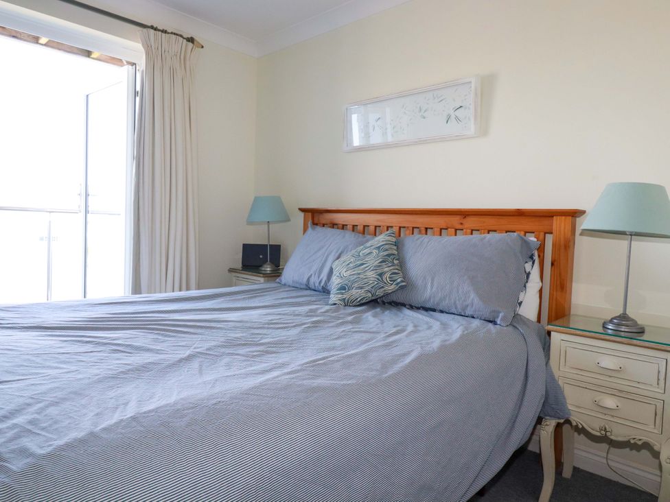 A bedroom with a bed and nightstand at Trewollock in Mevagissey