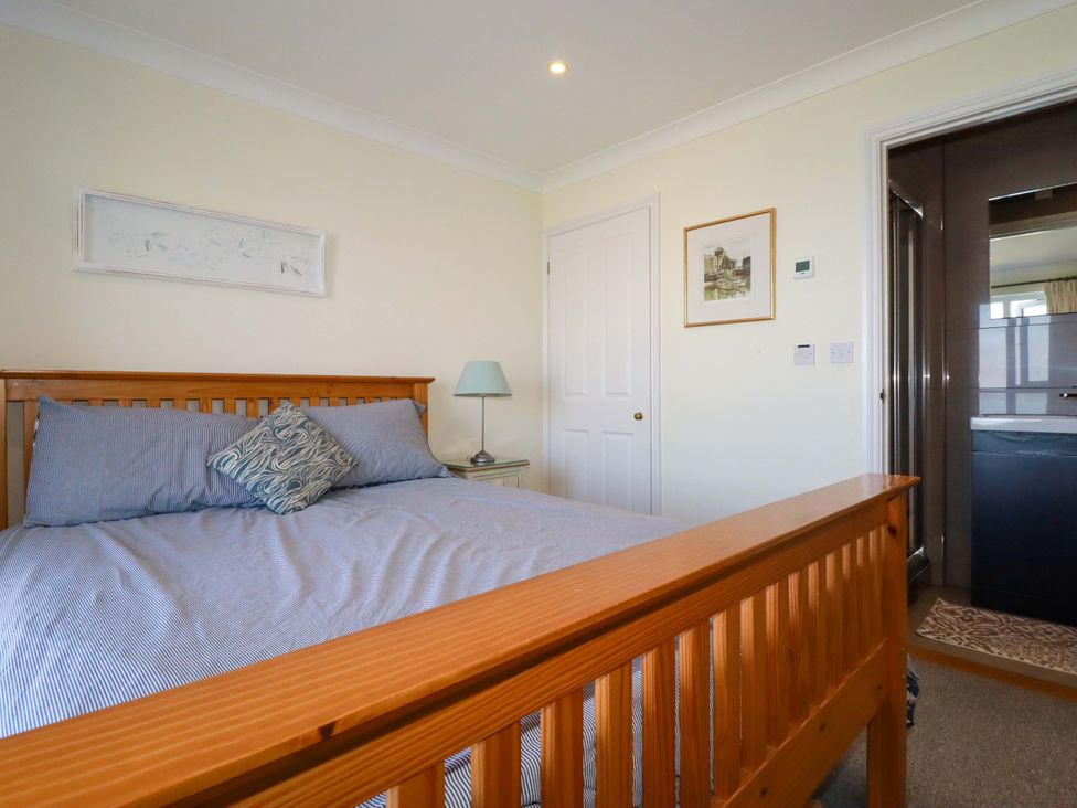 A bedroom with a bed and lamp at Trewollock in Mevagissey