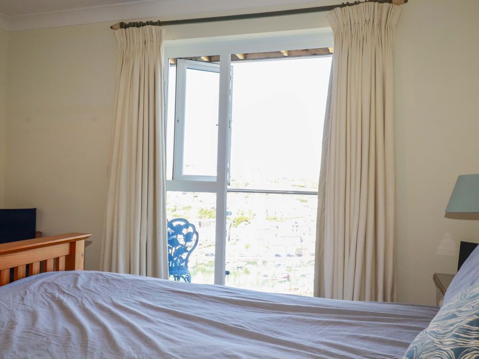A bedroom with a bed and window at Trewollock in Mevagissey