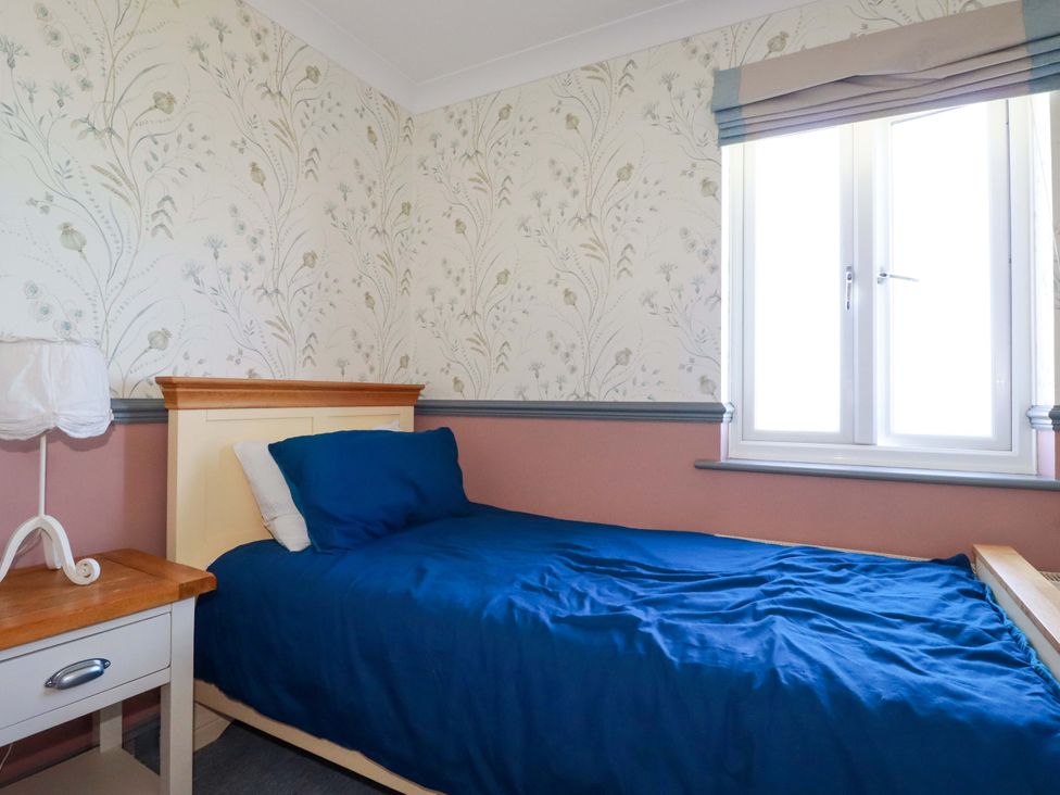 A bedroom with a single bed and bedside table at Trewollock in Mevagissey