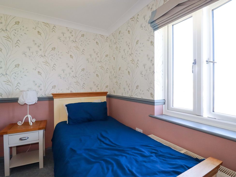 A bedroom with a bed and bedside table at Trewollock in Mevagissey