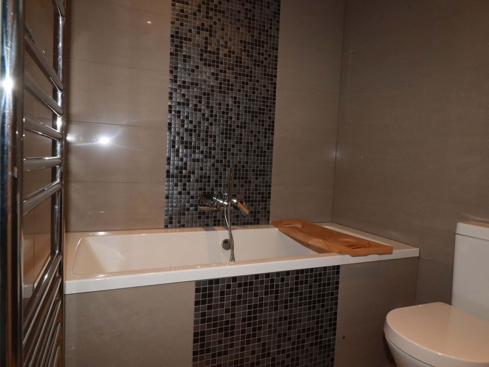 A bathroom with a bathtub and toilet at Trewollock in Mevagissey