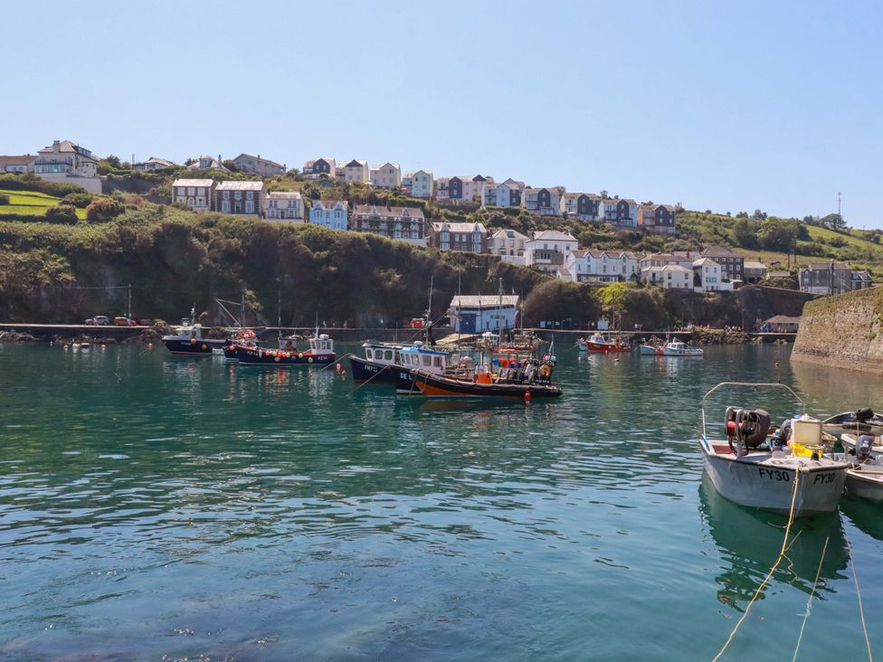 A view of boats in water with houses on hills at Trewollock in Mevagissey