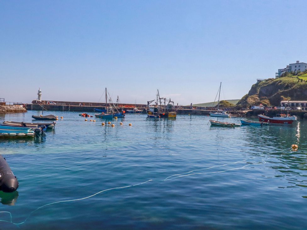 A harbor with boats and a lighthouse at Trewollock in Mevagissey