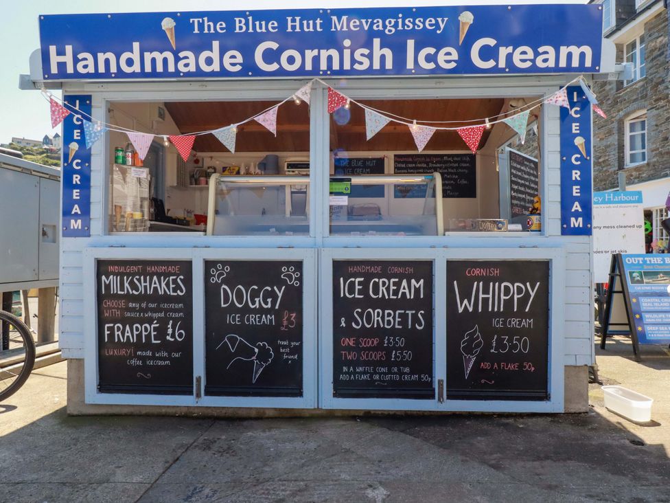 An ice cream stall with menu boards at The Blue Hut in Mevagissey
