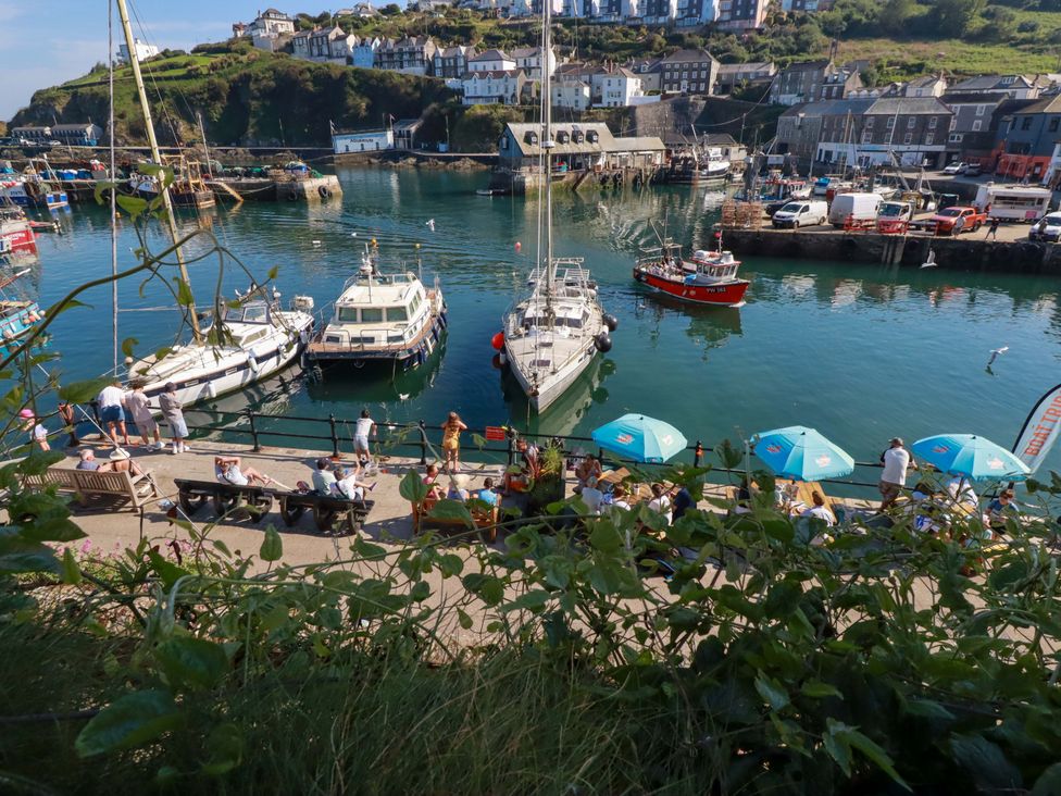 A harbor with boats and people sitting at tables in Mevagissey