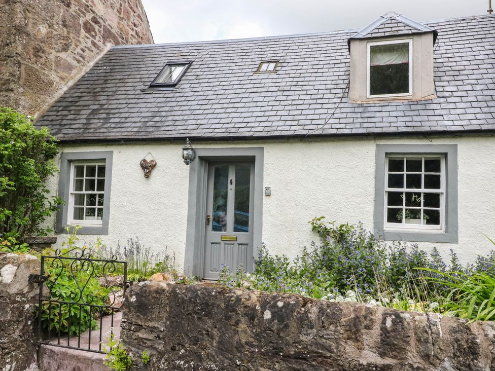 A cottage with a door and windows at Sciora Cottage
