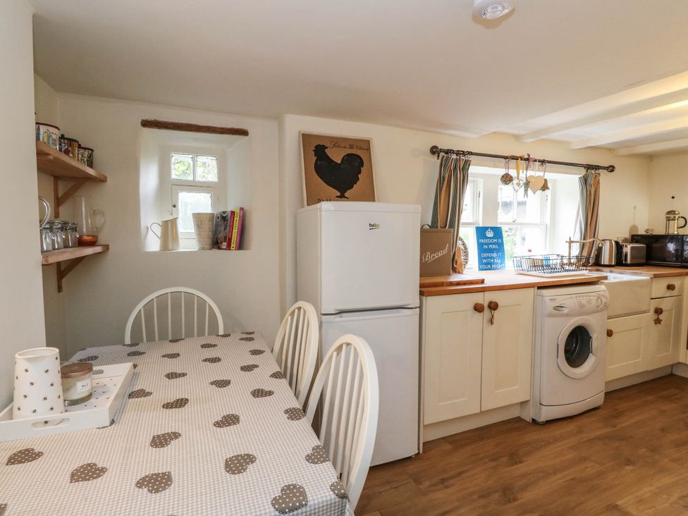 A kitchen with a table and chairs at Sciora Cottage