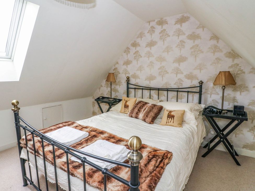 A bedroom with a bed and bedside lamp at Sciora Cottage 