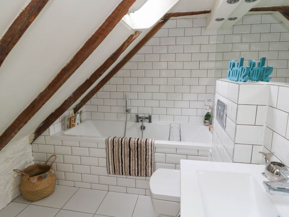 A bathroom with a bathtub and sink at Sciora Cottage