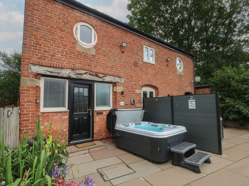 An outdoor area with a hot tub and patio at Barn 1 in Day Green near Rode Heath