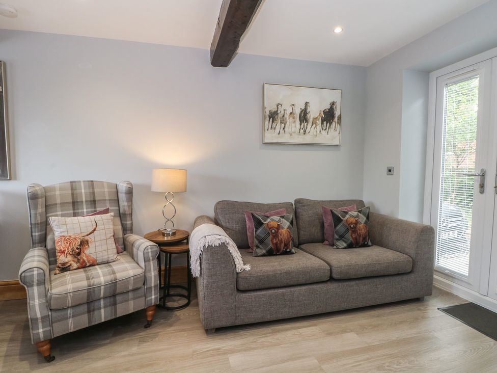 A living room with a sofa and an armchair at Barn 1 Day Green near Rode Heath