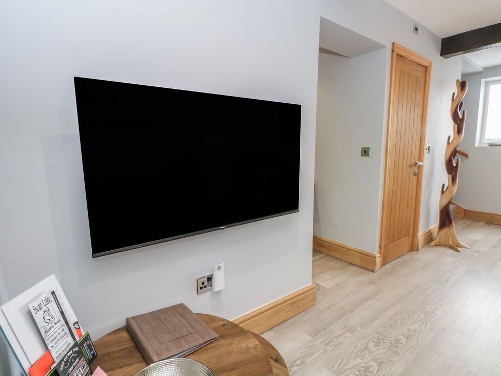 A living room with a television on the wall at Barn 1 Day Green near Rode Heath