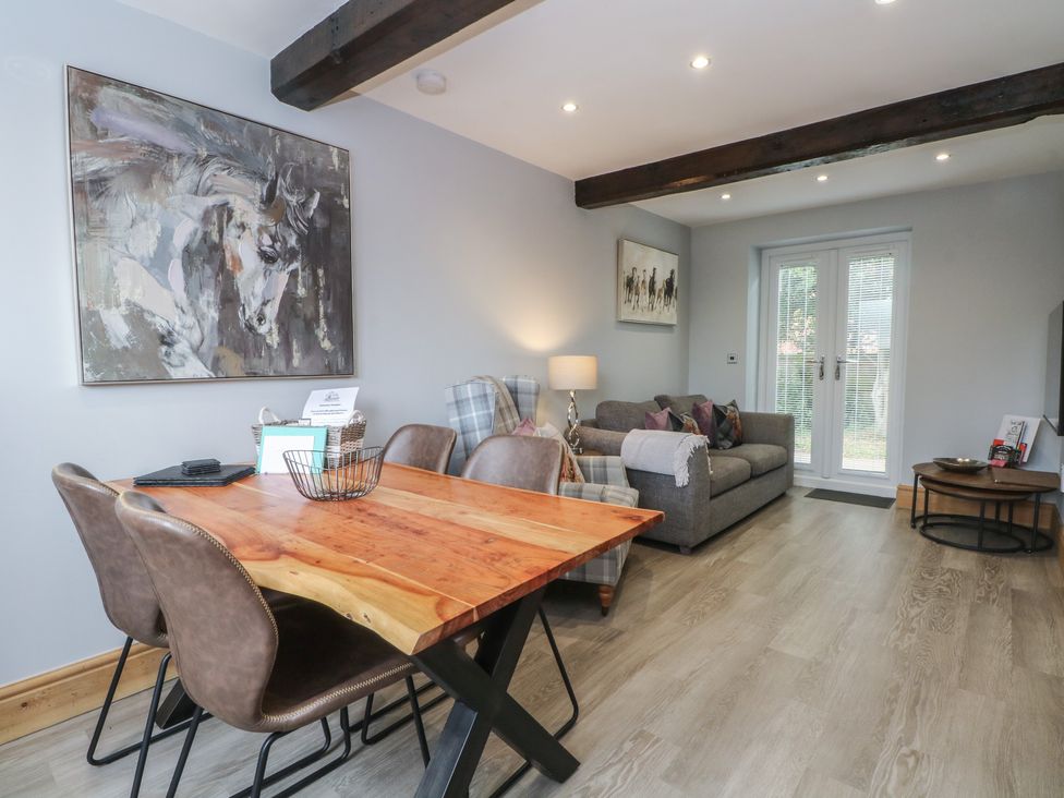 A living room with a dining area, sofa, and sliding door at Barn 1 in Day Green near Rode Heath