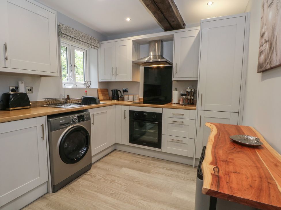 A kitchen with washing machine and oven at Barn 1 Day Green near Rode Heath
