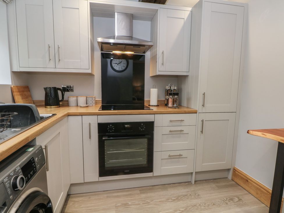 A kitchen with cabinets, oven, sink, and utensils at Barn 1 near Day Green near Rode Heath