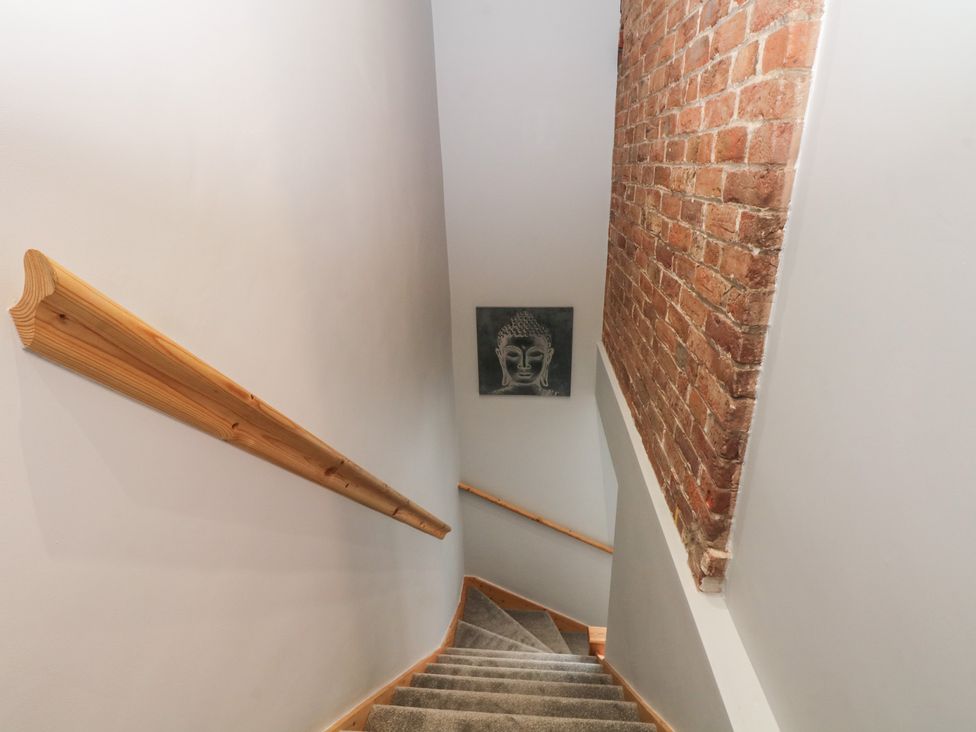 A staircase with a handrail and brick wall at Barn 1 Day Green near Rode Heath