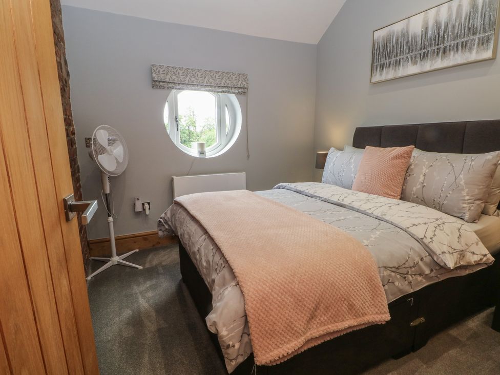 A bedroom with a bed and fan at Barn 1 Day Green near Rode Heath