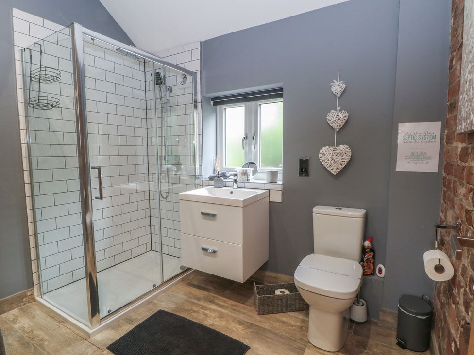 A bathroom with a shower, sink, and toilet at Barn 1 in Day Green near Rode Heath