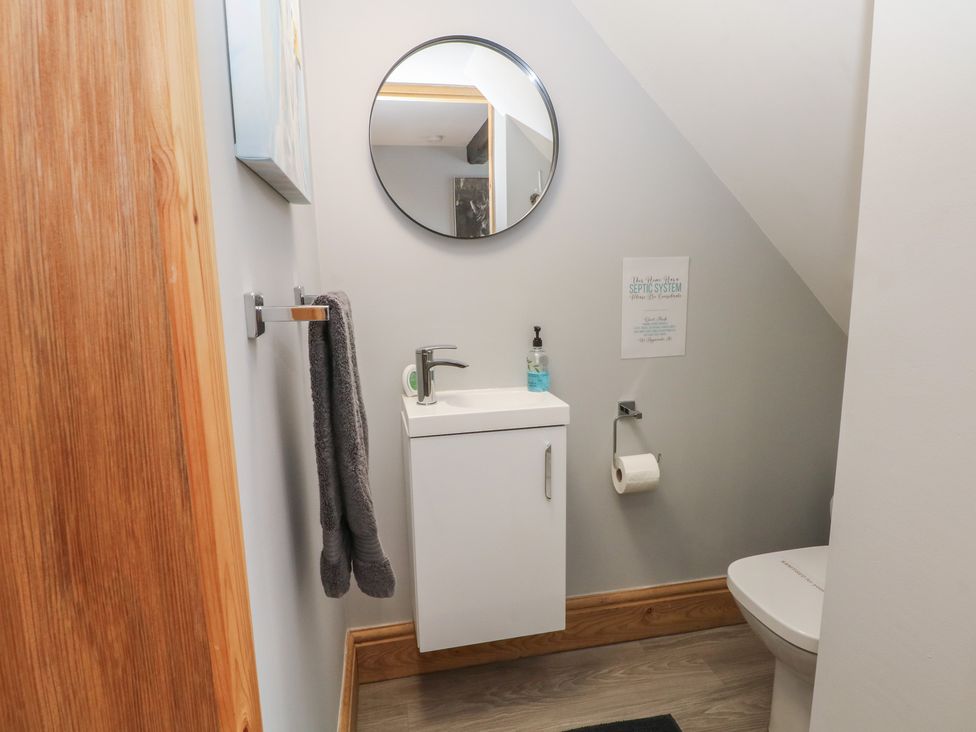 A bathroom with a sink, mirror, towel, and toilet at Barn 1 Day Green near Rode Heath