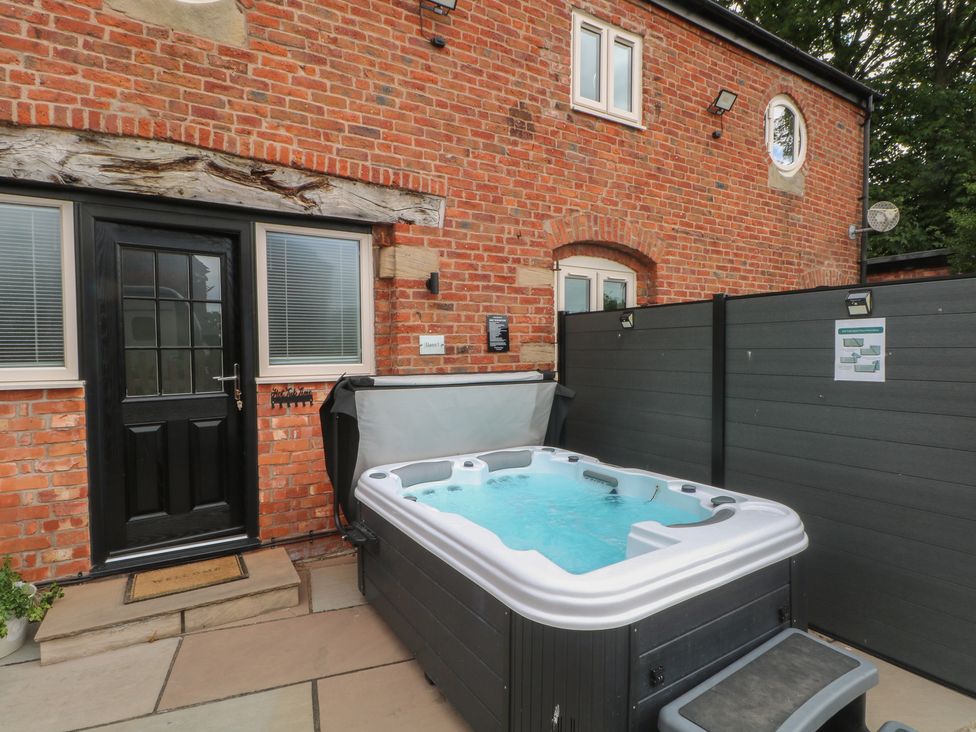 An outdoor area with a hot tub near the front door at Barn 1 Day Green near Rode Heath