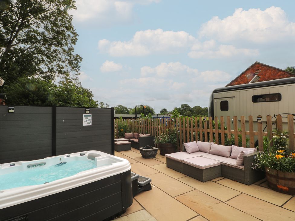 A garden with a hot tub and seating area at Barn 1 Day Green near Rode Heath