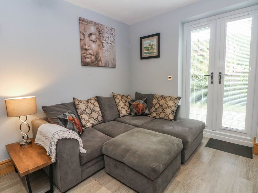 A living room with a sofa and lamp at Barn 2 Day Green near Rode Heath