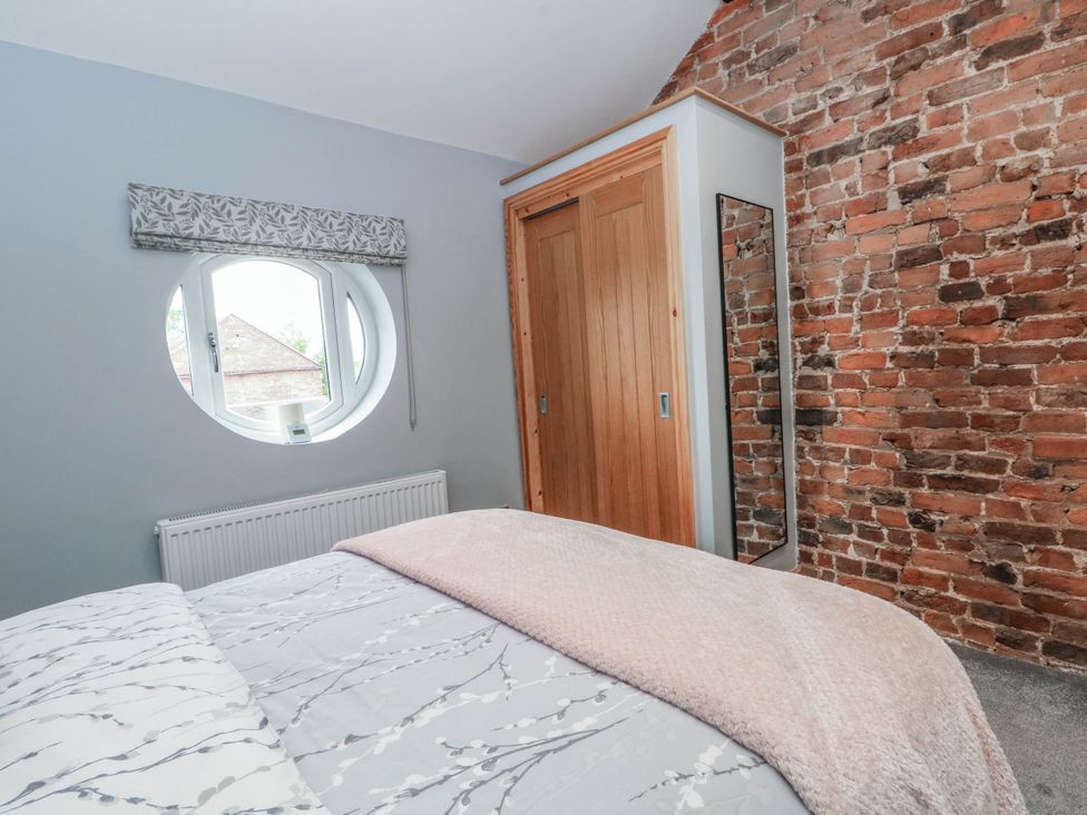 A bedroom with a bed and wardrobe at Barn 2 Day Green near Rode Heath