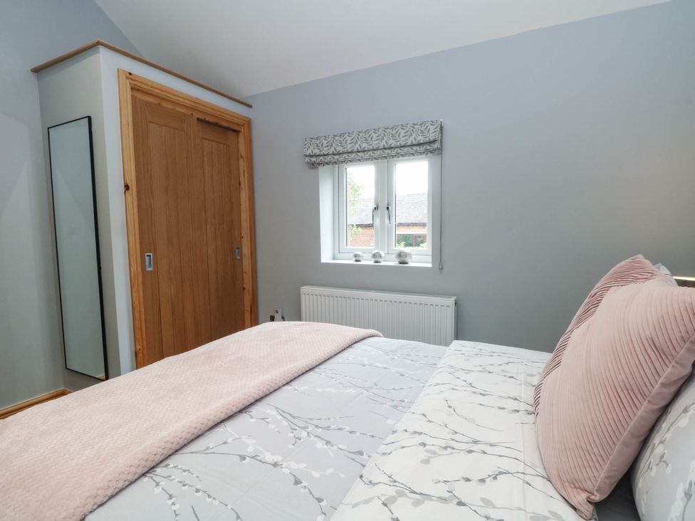 A bedroom with a bed and wardrobe at Barn 2 Day Green near Rode Heath