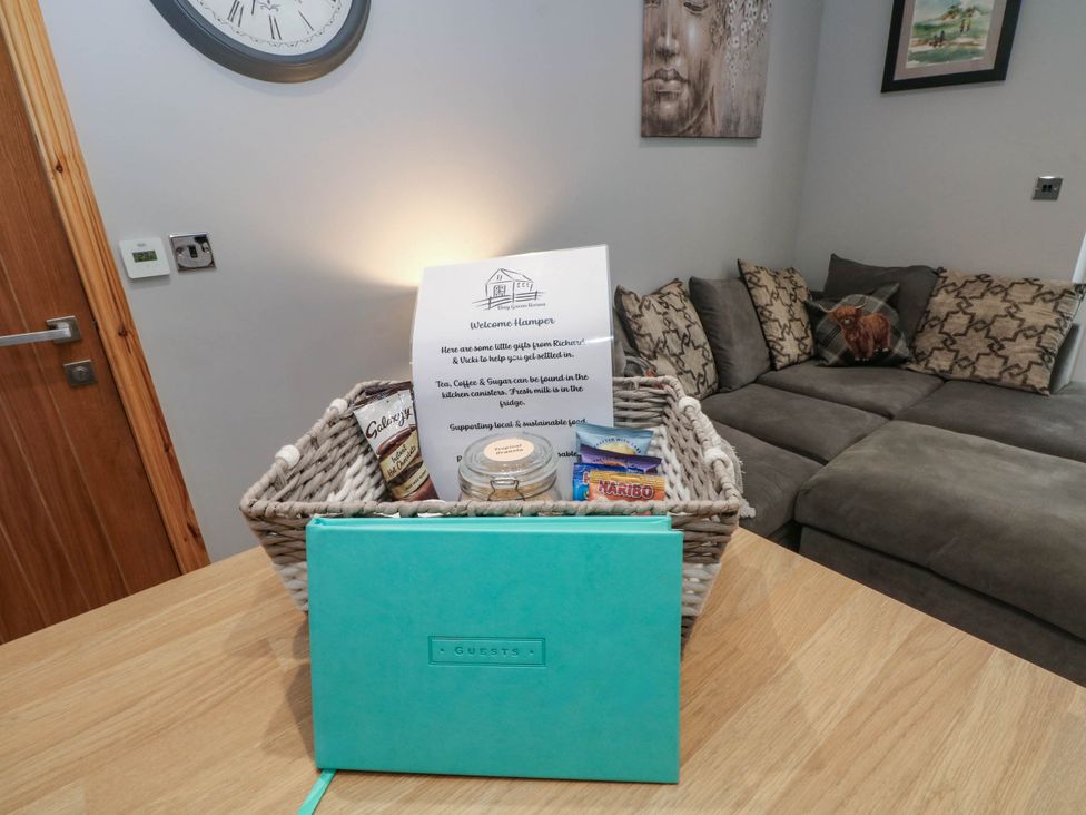 A welcome hamper with snacks and a guest book in a snug at Barn 2 Day Green near Rode Heath