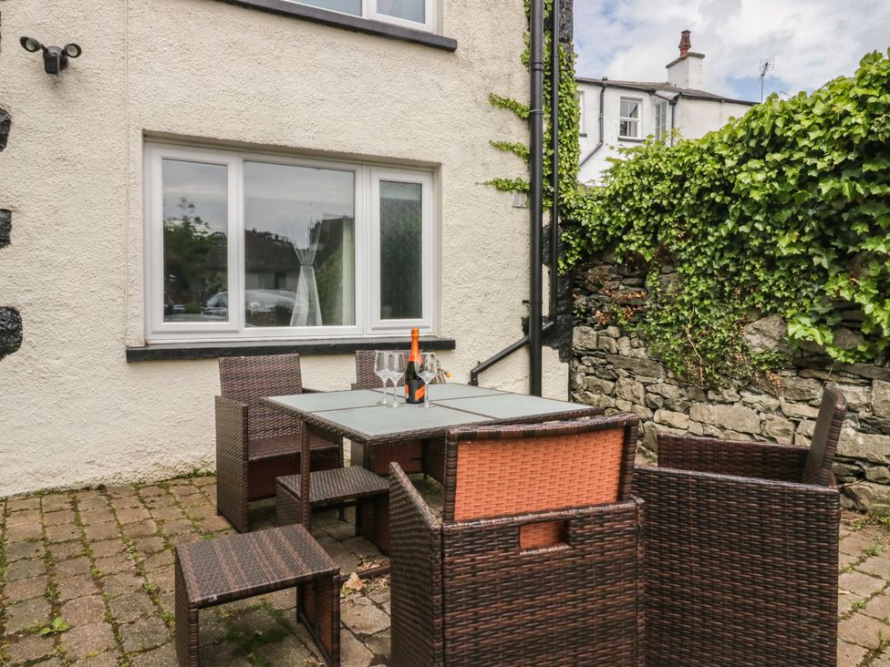 An outdoor seating area with a table and chairs at Courtyard Cottage