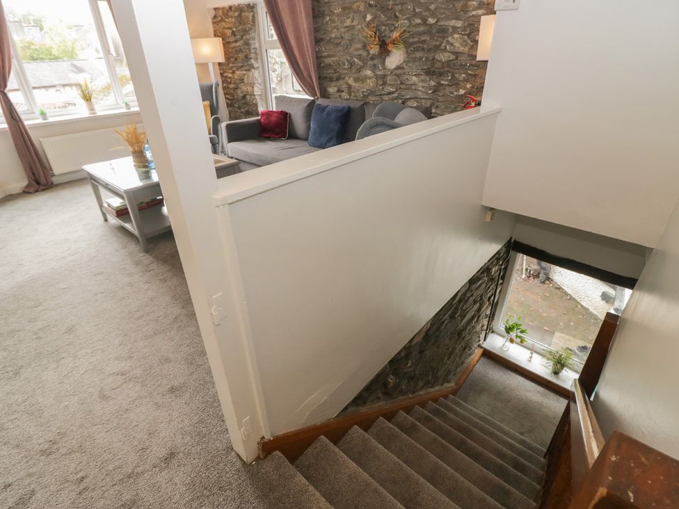 A living room with a sofa and table at Courtyard Cottage