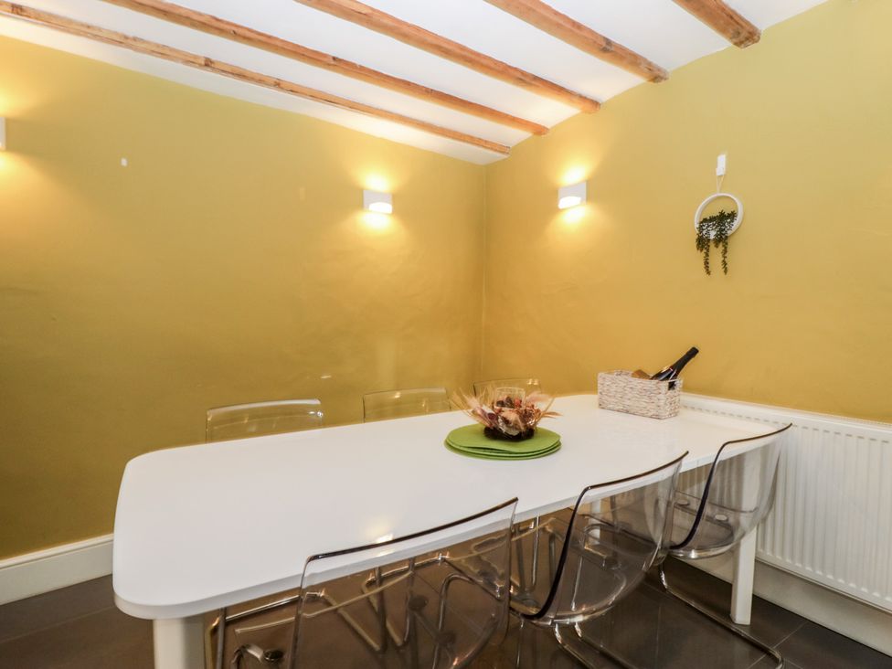 A dining room with a table and chairs at Courtyard Cottage