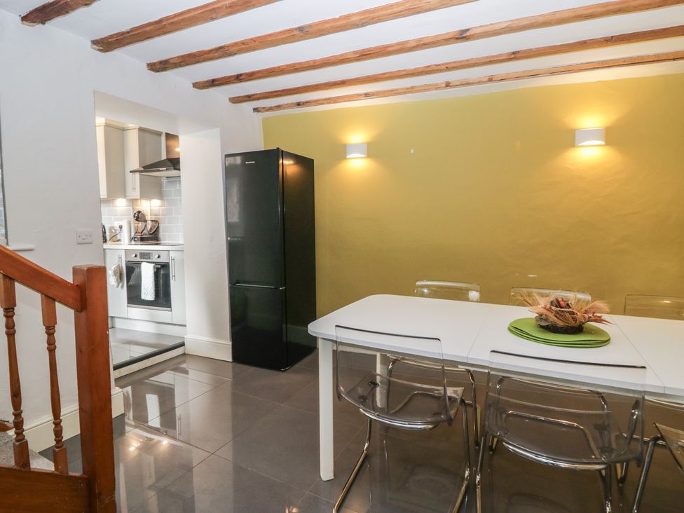 A kitchen with a dining table and chairs at Courtyard Cottage 