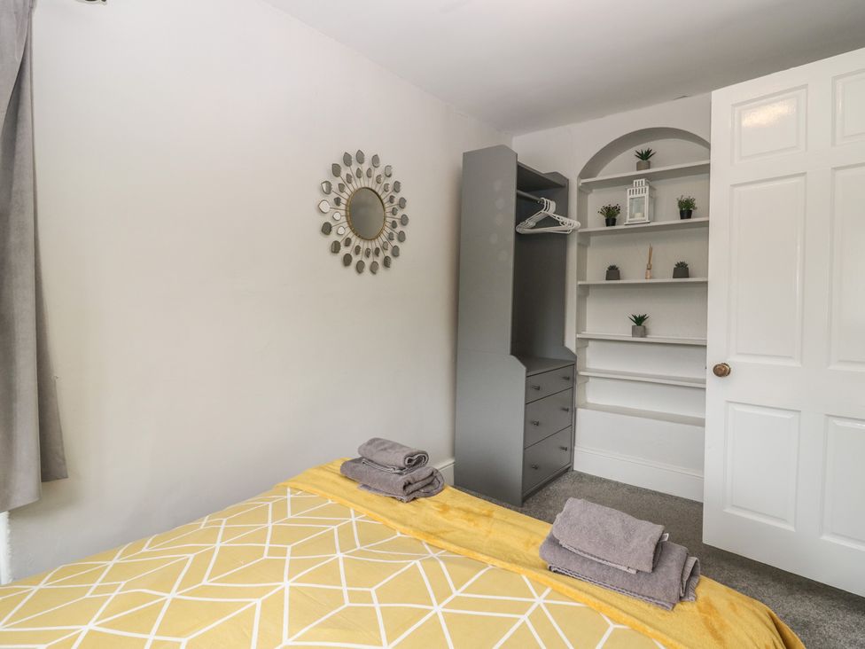 A bedroom with a bed and wardrobe at Courtyard Cottage