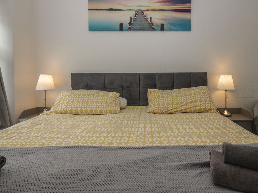 A bedroom with a bed and lamps at Courtyard Cottage