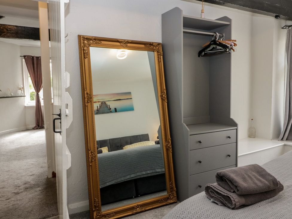 A mirror and wardrobe in a bedroom at Courtyard Cottage