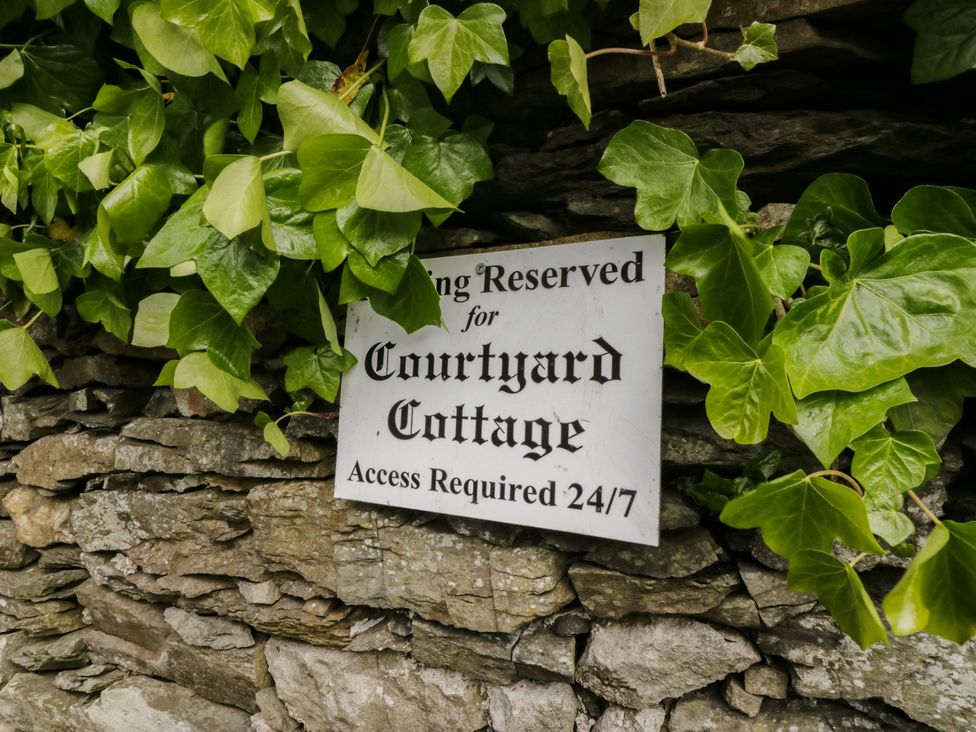 A reserved parking sign for Courtyard Cottage with ivy at Courtyard Cottage