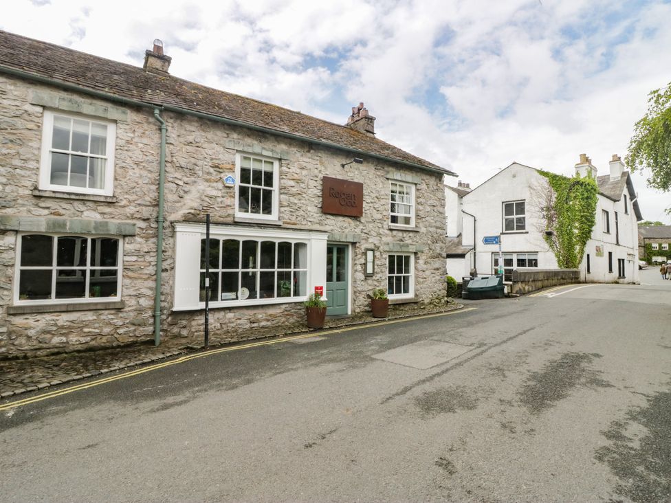 A stone building with windows and a sign on the street at Courtyard Cottage 