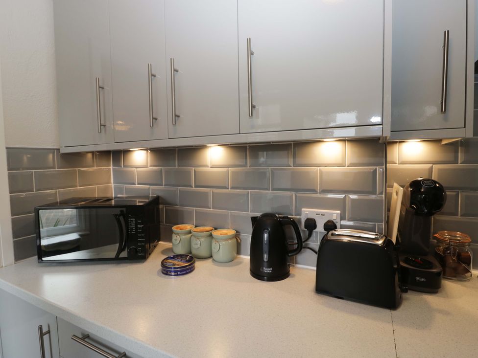 A kitchen with appliances including a microwave, kettle, toaster, and coffee machine at Courtyard Cottage, Cartmel