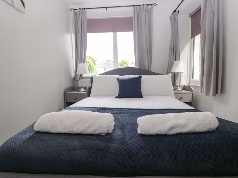 A bedroom with a bed and bedside table at Courtyard Cottage in Cartmel