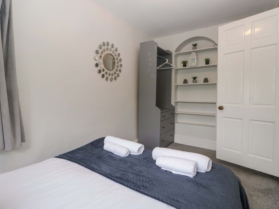 A bedroom with a bed and towels on it at Courtyard Cottage in Cartmel