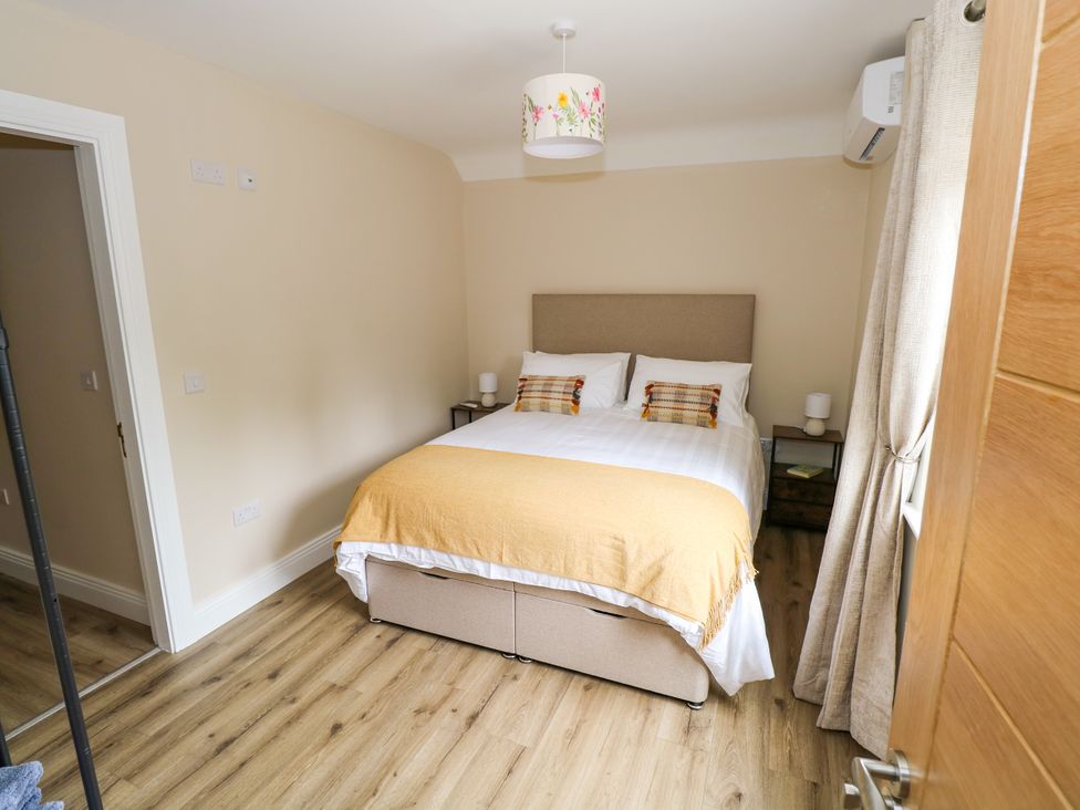 A bedroom with a bed and nightstand at Mayfly Cottage