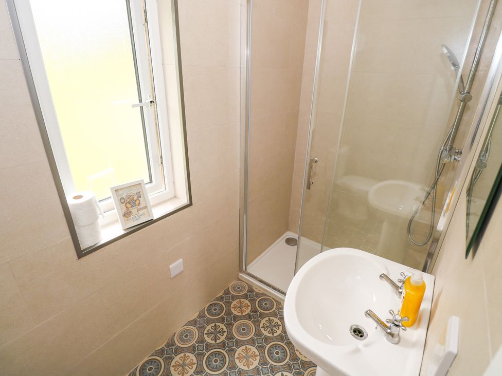 A shower and sink in a bathroom at Mayfly Cottage