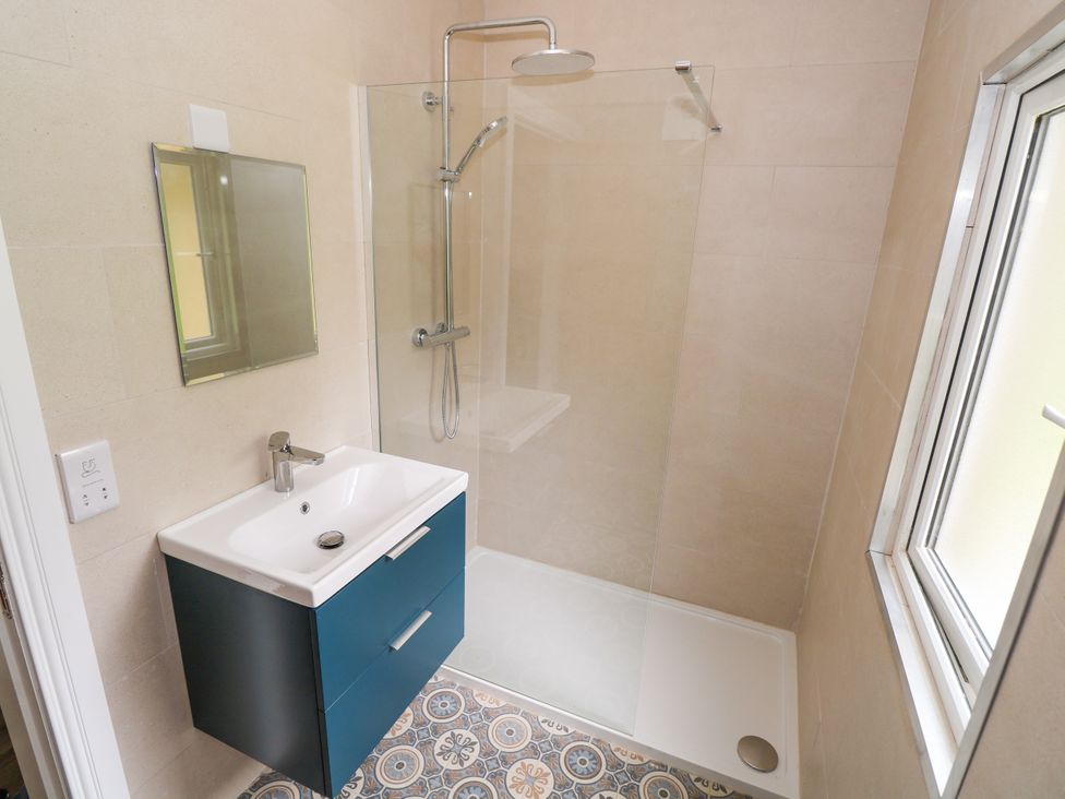 A bathroom with a shower and sink at Mayfly Cottage