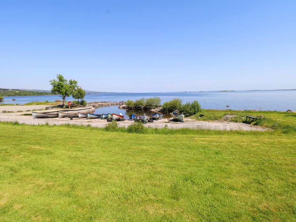 A shoreline with boats and trees at Mayfly Cottage in 