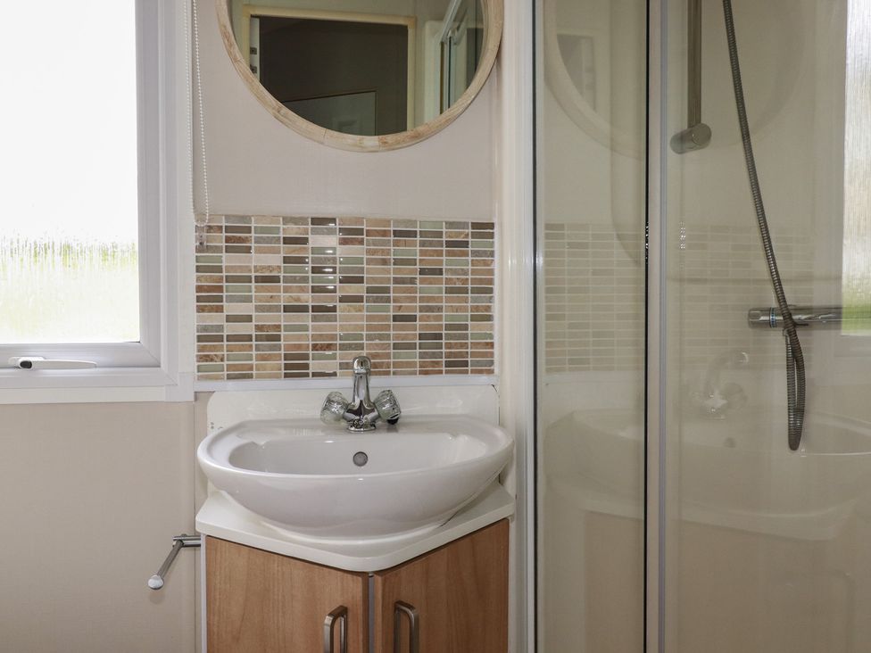A bathroom with a sink and mirror at Tucked Away in Newquay