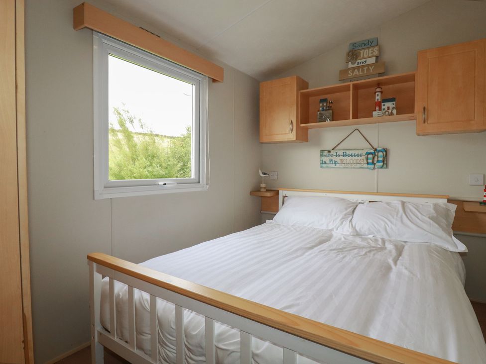 A bedroom with a bed and shelf at Tucked Away in Newquay