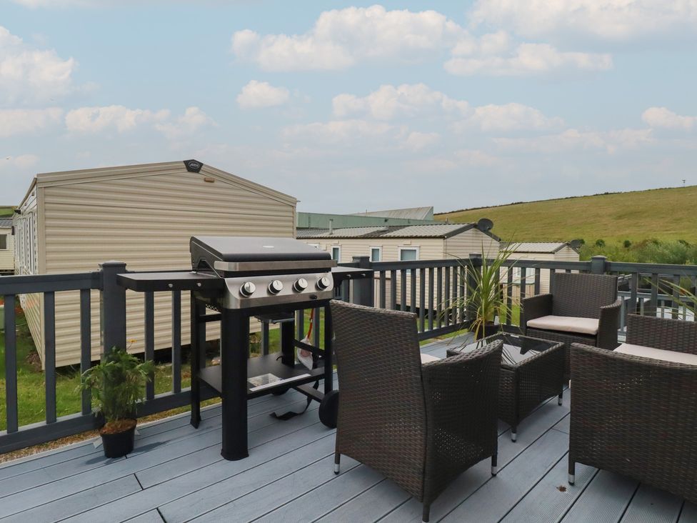 An outdoor area with a barbeque grill and seating at Tucked Away in Newquay